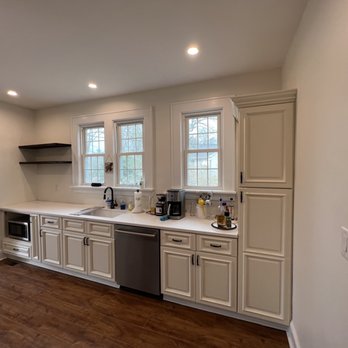 Triad Extra Hands - a kitchen with white cabinets and wood floors - Fences & Gates Near Me Triad Extra Hands - a kitchen with white cabinets and wood floors - Fences & Gates Near Me