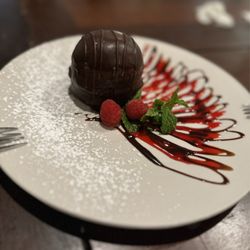 Truffle Bistro - Chocolate mousse bomb with raspberry sauce.