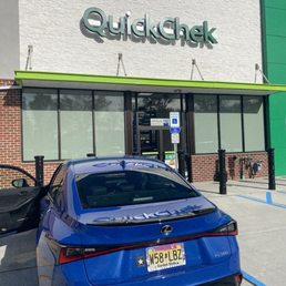 a blue car parked in front of a store