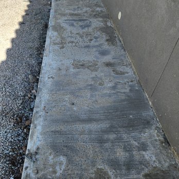 Green Renovations Landscaping - a concrete sidewalk with a water tank in the background - Lawn Services Near Me