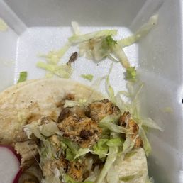 a chicken taco in a styrofoam container a chicken taco in a styrofoam container