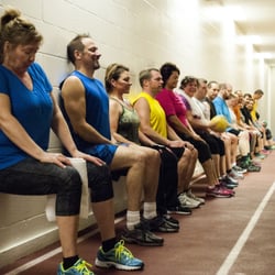 Metro Fitness Club - Metro42 Body Transformation Program participants doing a wall sit along the track.