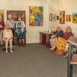 An exhibition opening, director is at right