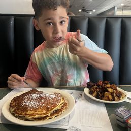 Three stack of Oreo pancakes and home fries.