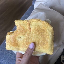 Beef Patty with coco bread behind it Beef Patty with coco bread behind it