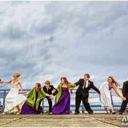 Wallflower Photography - Humorous award-winning wedding photo staged as if the bride and their combined families were keeping the umbrella-clutching g...