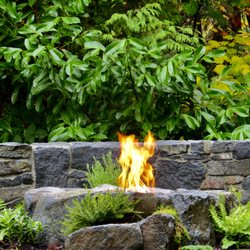 Blue Bear Landscape Construction - Basalt boulder fire pit, mortared basalt sitting wall and lush planting create the ultimate west coast vibe.