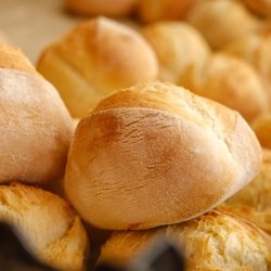 Maple Grove Farmers Market - A close-up view of crusty, golden-brown artisan bread rolls displayed at a local bakery vendor booth...