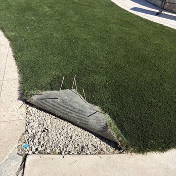 Reborn Lawns - No leveling sand found. Five patchwork pieces of turf were used to fill this section. - Artificial Turf Near Me