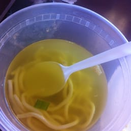 a bowl of soup with noodles and a spoon a bowl of soup with noodles and a spoon