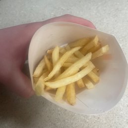 a person holding a container of french fries