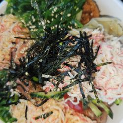 Poke bowl with mixed greens, pepper tuna, salmon, spicy tuna, seaweed salad, crab, seaweed