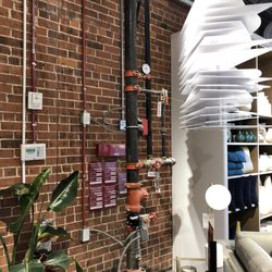 west elm - Exposed brick and pipes.