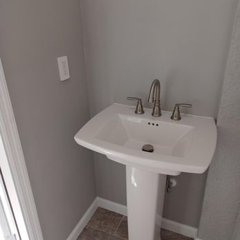 Elevation Contractors - a white pedestal sink in a bathroom - General Contractors Near Me Elevation Contractors - a white pedestal sink in a bathroom - General Contractors Near Me