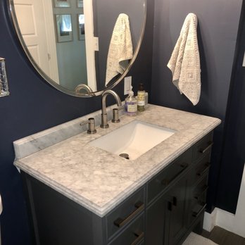 Floors and More - a bathroom with a sink and mirror - Flooring Near Me - Smithville, Texas