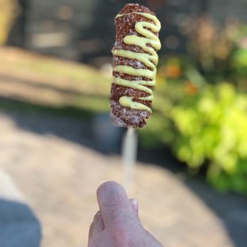 South Philly Steaks - a hand holding a chocolate and mustard skewer - Food Trucks Near Me