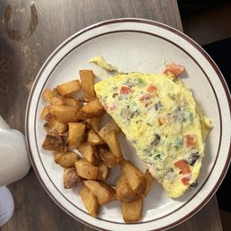 Veggie omelette with tomatoes and cheese with home fries Veggie omelette with tomatoes and cheese with home fries