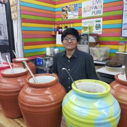 a man standing in front of a row of pots