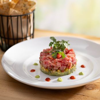 Seasons 52 - Ahi Tuna Tartare features layers of handline tuna, avocado, tropical salsa, sriracha and wasabi - New American Near Me - Houston, Texas