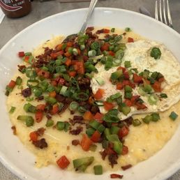 Grits with bacon, cheese, peppers and an added egg. Grits with bacon, cheese, peppers and an added egg.