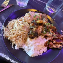Three meat plate with noodle side, crispy brussels sprouts, and rice.