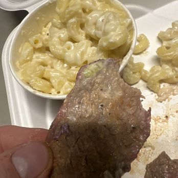 ROUTTIE'S BBQ - a hand holding a piece of meat and macaroni and cheese - Barbeque Near Me - Steamboat Springs, Colorado