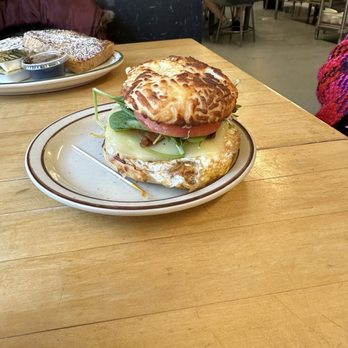 Cafe Rosetta - Bagel Sandwich: Asiago Bagel, American, eggs, bacon, spinach, sprouts, tomato, and Chipotle Mayo - Coffee & Tea Near Me - Calumet, Michigan Cafe Rosetta - Bagel Sandwich: Asiago Bagel, American, eggs, bacon, spinach, sprouts, tomato, and Chipotle Mayo - Coffee & Tea Near Me - Calumet, Michigan