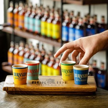 Eastside Distilling - a hand reaching for three cups of coffee - Distilleries Near Me Eastside Distilling - a hand reaching for three cups of coffee - Distilleries Near Me