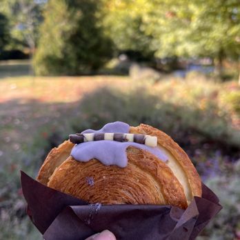 Lumiere Cafe - a hand holding a croissant - Coffee & Tea Near Me - Vancouver, British Columbia