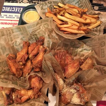 Wingstop - Louisiana rub and lemon pepper 10pc on the left, lemon pepper and garlic parm 10pc on the right, and fries at the top - Chicken Wings Near Me - South San Francisco, California