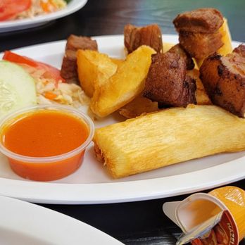 El Cielo - a woman sitting at a table with plates of food - Peruvian Near Me - Gardena, California