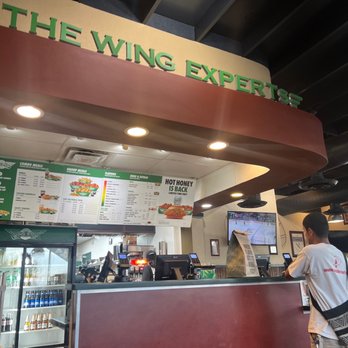 Wingstop - a man standing in front of a counter - Chicken Wings Near Me - San Antonio, Texas Wingstop - a man standing in front of a counter - Chicken Wings Near Me - San Antonio, Texas