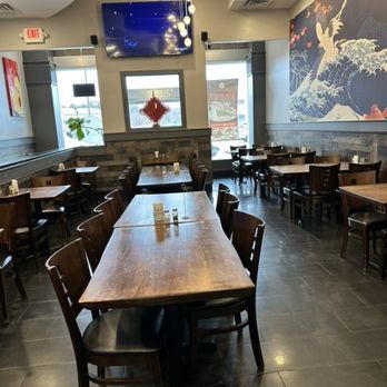 Chau's Cafe - Dining room - Interior of Chau's Cafe featuring wooden tables and chairs, wall art with Asian motifs, and a large TV mounted on the wall. - Chinese Near Me - Ashburn, Virginia