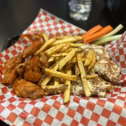 a basket of chicken wings and fries
