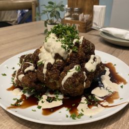 a plate of meatballs covered in sauce and garnished with parsley a plate of meatballs covered in sauce and garnished with parsley