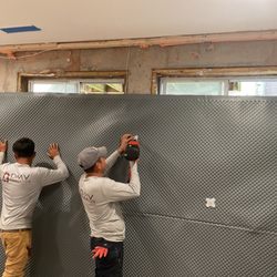 DMV Foundation Solutions - Crew installing drainboard on foundation wall.
