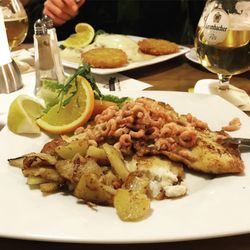 Zum Insulaner - Vorne: Schollenfilet "Borkum Riff" mit Nordseekrabben und Bratkartoffeln, hinten Schweinerücken vom Grill "Schweizer Art".