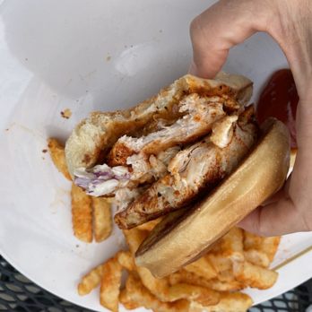 Fenders Diner - a hand holding a sandwich and french fries - Diners Near Me - Cornelia, Georgia