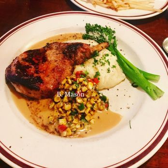 Mike's American - Berkshire Pork Chop12 oz hickory grilled mashed potatoes, grilled broccolini & Huber's roast corn salsa. - American Near Me - Springfield, Virginia