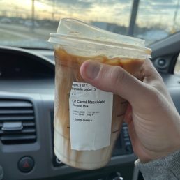 a hand holding a cup of iced coffee