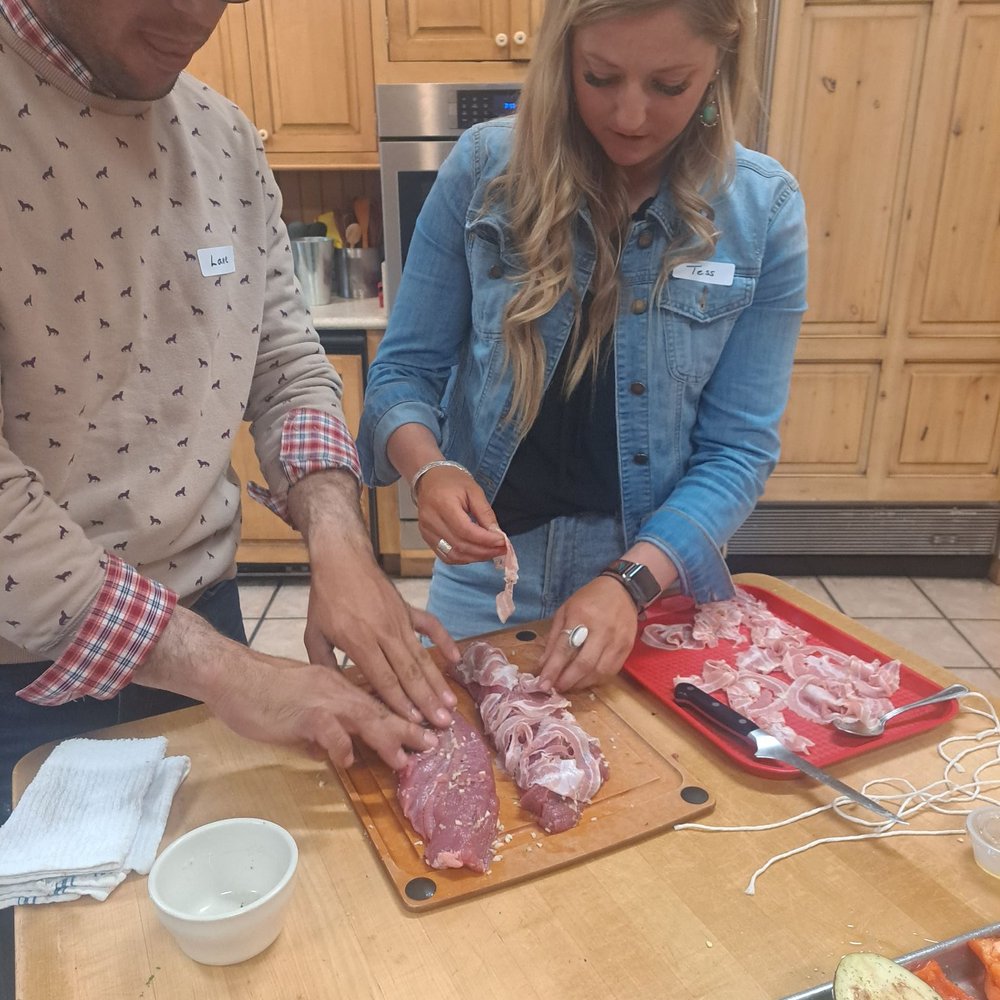 Nothing To It Culinary Center - Tess and Lane from our cooking team are wrapping the pork tenderloin in prosciutto. - Cooking Schools Near Me - Reno, Nevada Nothing To It Culinary Center - Tess and Lane from our cooking team are wrapping the pork tenderloin in prosciutto. - Cooking Schools Near Me - Reno, Nevada