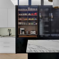 Your Kitchen & Bath - Custom Kitchen cabinetry appliance center with pocket doors and walnut wood interior.
