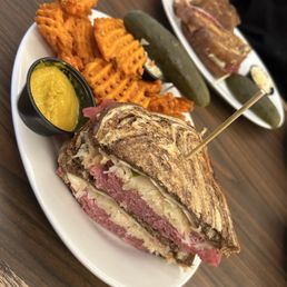 Classic Reuben with sweet potato waffle fries, coleslaw, pickle and side of Ray's yellow mustard. Classic Reuben with sweet potato waffle fries, coleslaw, pickle and side of Ray's yellow mustard.