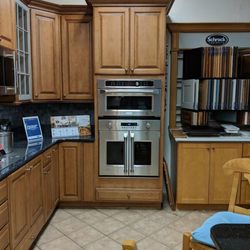 Bray & Scarff - kitchen showroom with wooden cabinetry, tile flooring,  and two built in stainless steel wall ovens