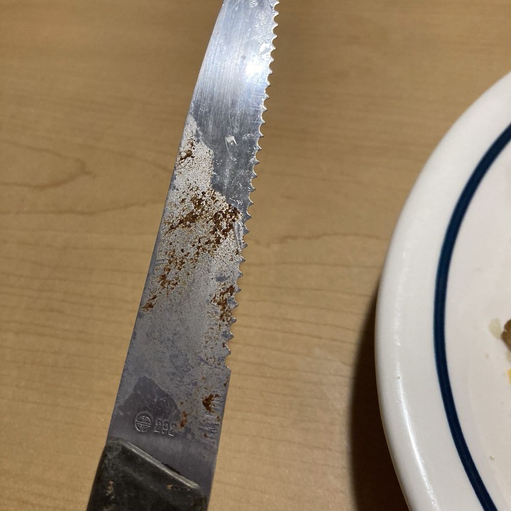 A dirty knife from kitchen and a chicken sandwich