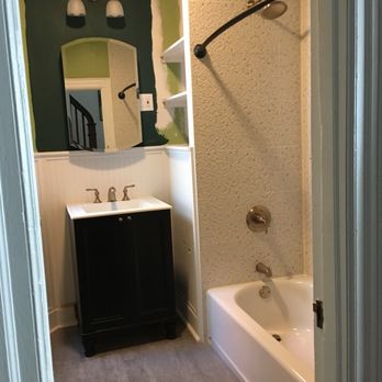 Stretch Construction - a bathroom with a sink, tub, and mirror - General Contractors Near Me Stretch Construction - a bathroom with a sink, tub, and mirror - General Contractors Near Me