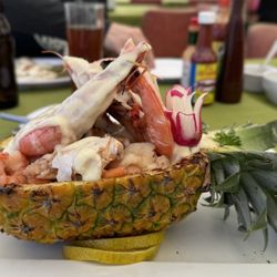 Los Pericos - Pineapple boat with seafood medley and cheese