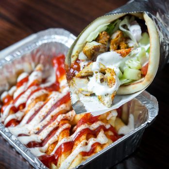 Austin’s Habibi  -  a hand holding a burrito - Mediterranean Near Me - Austin, Texas