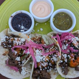 Korexican Tacos: bulgogi beef, spicy cucumber mix, caramelized onions served with house-made green salsa verde, black beans, sriracha mayo Korexican Tacos: bulgogi beef, spicy cucumber mix, caramelized onions served with house-made green salsa verde, black beans, sriracha mayo