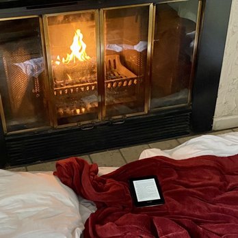 LakeFront Lodge - Cozied up to the fireplace with a book on a rainy day. - Hotels Near Me - McHenry, Maryland LakeFront Lodge - Cozied up to the fireplace with a book on a rainy day. - Hotels Near Me - McHenry, Maryland